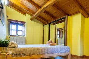 een slaapkamer met een bed in een kamer met gele muren bij La casita de la Senda 