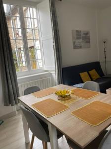 a dining room table with chairs and a couch at Charmant appartement T2 plein centre ville in Saint-Brieuc