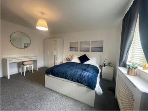 ein Schlafzimmer mit einem Bett mit einer blauen Decke in der Unterkunft Woolwich 2Bedroom Apartment in London