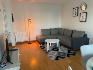 a living room with a couch and a table at Appartement moderne cœur des châteaux de la Loire - Parking in Blois