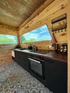 a kitchen in a log cabin with two windows at Ô Naturel Lodge Lifou in Lifou