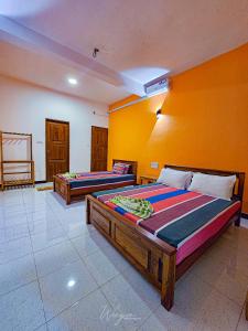 two beds in a room with yellow walls at Yoma Wild Hotel in Udawalawe +40 photos