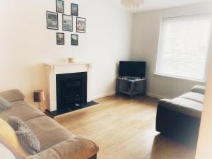 a living room with a couch and a fireplace at Ground floor Central 1 bed with parking in Aberdeen