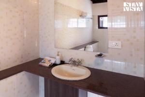 a bathroom with a sink and a mirror at StayVista at Vale Echoes - Breakfast Included in Munnar