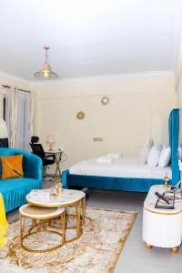 een kamer met een bed, een bank en een tafel bij Epic Home By Edmor Suite in Nairobi