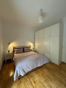 een slaapkamer met een groot bed en witte kasten bij Noula's Home in Athene