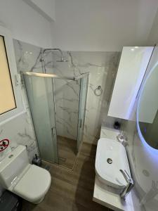 een badkamer met een douche, een toilet en een wastafel bij Noula's Home in Athene