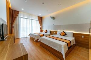 een hotelkamer met 2 bedden en een flatscreen-tv bij KHÁCH SẠN HÀ PHƯƠNG Tánh Linh in Phan Thiet