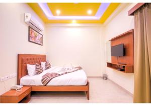 a bedroom with a bed with a tv on the wall at Amit House in Greater Noida