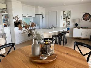 uma cozinha com uma mesa com um vaso com flores em Mima's Nest - Beach House em Lulworth