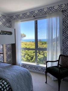 um quarto com uma cama e uma grande janela em Mima's Nest - Beach House em Lulworth