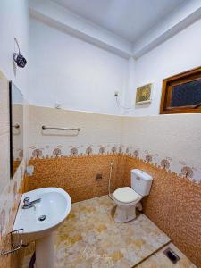 a bathroom with a toilet and a sink at Yoma Wild Hotel in Udawalawe