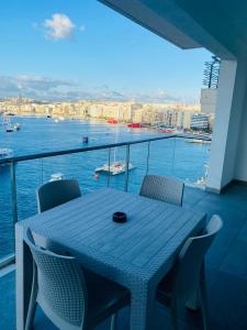 a table on a balcony with a view of the water at Sliema Seaview & seafront- APT 9, 49 Tigne Point Mansions in Sliema