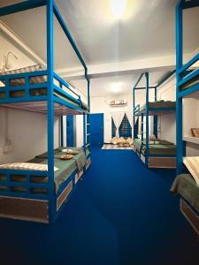 2 stapelbedden in een kamer met blauw tapijt bij House Of Surf Hostel for Women in Varkala