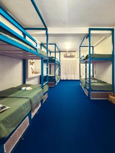 2 łóżka piętrowe w pokoju z niebieskim dywanem w obiekcie House Of Surf Hostel for Women w mieście Varkala