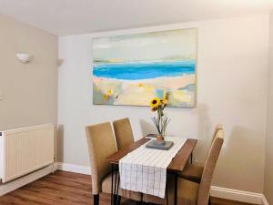 a dining room table with a vase of flowers on it at Exquisite 2 bedroom, Sleeps 4, Wifi LONG STAY WORK LEISURE CONTRACTOR - Lolite Apartment in Cambridge