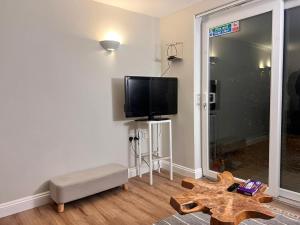 uma sala de estar com uma televisão de ecrã plano na parede em Exquisite 2 bedroom, Sleeps 4, Wifi LONG STAY WORK LEISURE CONTRACTOR - Lolite Apartment em Cambridge