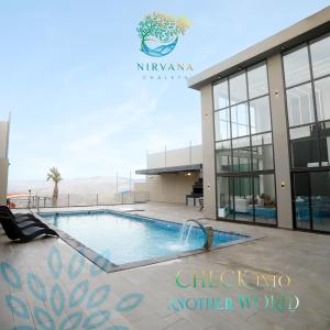 a swimming pool in front of a building at Nirvana Chalets in Jerash