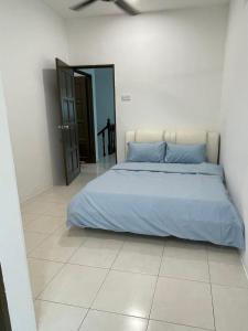 - une chambre avec un lit doté d'oreillers bleus dans l'établissement Eyu Sweet Home in Sitiawan 10-13 pax free wifi, à Sitiawan