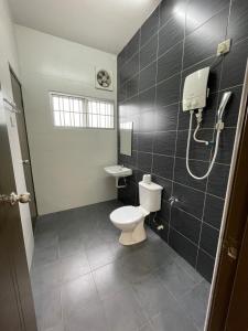 La salle de bains est pourvue d'une douche et de toilettes. dans l'établissement Eyu Sweet Home in Sitiawan 10-13 pax free wifi, à Sitiawan