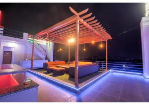 a rooftop patio with a wooden pergola at night at Amit House in Greater Noida