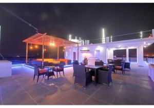 a patio with tables and chairs at night at Amit House in Greater Noida