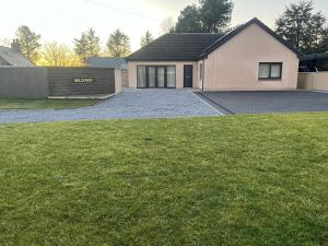 a house with a driveway in front of a yard at Beldorny in Kingston