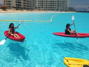 dwoje osób w kajakach w wodzie w basenie w obiekcie Departamento Resort Laguna del Mar w mieście La Serena