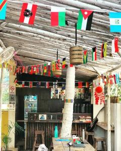 um restaurante com bandeiras penduradas num tecto de madeira em THE MUSAFIR HOSTEL em Anjuna