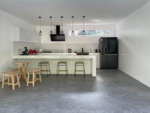 a kitchen with a white counter and stools in it at KPG Suite Dream in Ban Nua