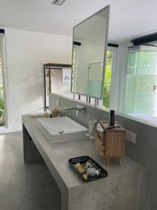 a bathroom with a white sink and a mirror at KPG Suite Dream in Ban Nua