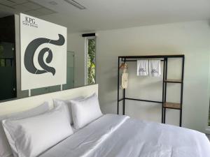 a white bed with white pillows in a room at KPG Suite Dream in Ban Nua