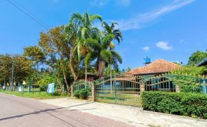 une clôture devant une maison avec un palmier dans l'établissement Forever House, à Ko Muk
