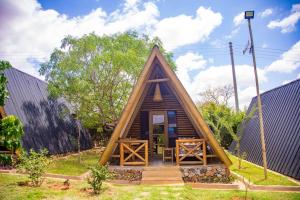 Voi的住宿－Boma Simba Safari Lodge，一个带三角形屋顶的小小木屋