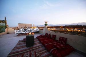 d'un balcon avec des chaises, une table et des lumières. dans l'établissement Riad Oum B&B, à Marrakech