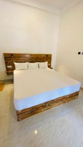 1 dormitorio con 1 cama grande con sábanas y almohadas blancas en Mellow Yellow, en Ahangama