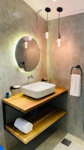 アハンガマにあるMellow Yellowの白い洗面台と鏡のあるバスルーム