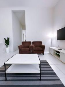 a living room with a couch and a coffee table at Cosy House For Family Or Group In Bukit Beruang Melaka in Kampong Pengkalan Batu
