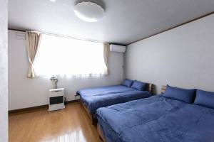 2 camas en una habitación con ventana y ventana en THE NORTH PEAK NAKAFURANO, en Nakafurano