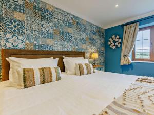 a bedroom with a large white bed with blue walls at 3 Bed in Westward Ho 89869 in Westward Ho