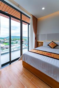 een slaapkamer met een bed en een groot raam bij KHÁCH SẠN HÀ PHƯƠNG Tánh Linh in Phan Thiet