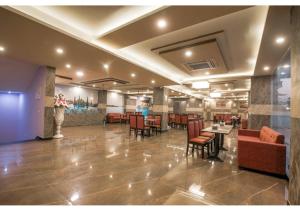 a lobby with a waiting area with tables and chairs at Amit House in Greater Noida