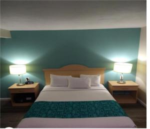 A bed or beds in a room at Howard Johnson by Wyndham Santa Cruz Beach Boardwalk