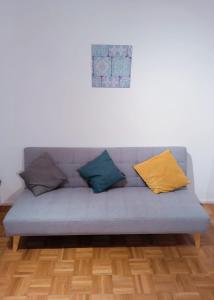 a couch with four pillows on it in a living room at Sonniges 2-Zimmer-Gartenapartment in Bietigheim-Bissingen