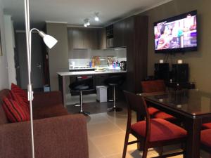 kuchnia i salon ze stołem i telewizorem w obiekcie Departamento Resort Laguna del Mar w mieście La Serena