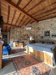 1 dormitorio con 1 cama grande y pared de piedra en taş ev, en Karaburun