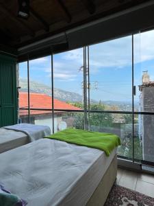 1 dormitorio con 2 camas y ventana grande en taş ev en Karaburun