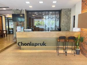 Chonlapruk Lakeside Hotel في Ban Si Than: مطعم مع كونتر مع كرسيين