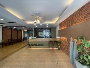 a lobby with a bar and a brick wall at Chonlapruk Lakeside Hotel in Ban Si Than