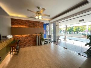 a living room with a brick wall and a ceiling fan at Chonlapruk Lakeside Hotel in Ban Si Than